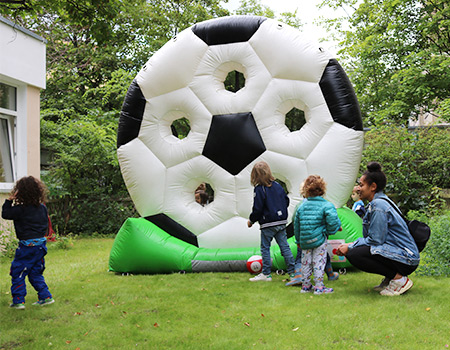 Der Campus mit vielen sozialen Projekten wird eingeweiht. Zu sehen sind Erwachsene und Kinder auf dem Sommerfest.