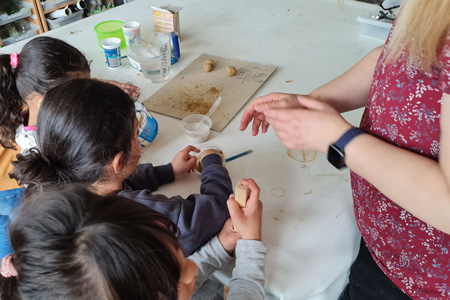 Frau Göhler erklärt den Kindern, wie man eine Samenkugel herstellt