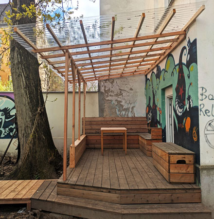 Holzterrasse mit Dach im Hinterhof