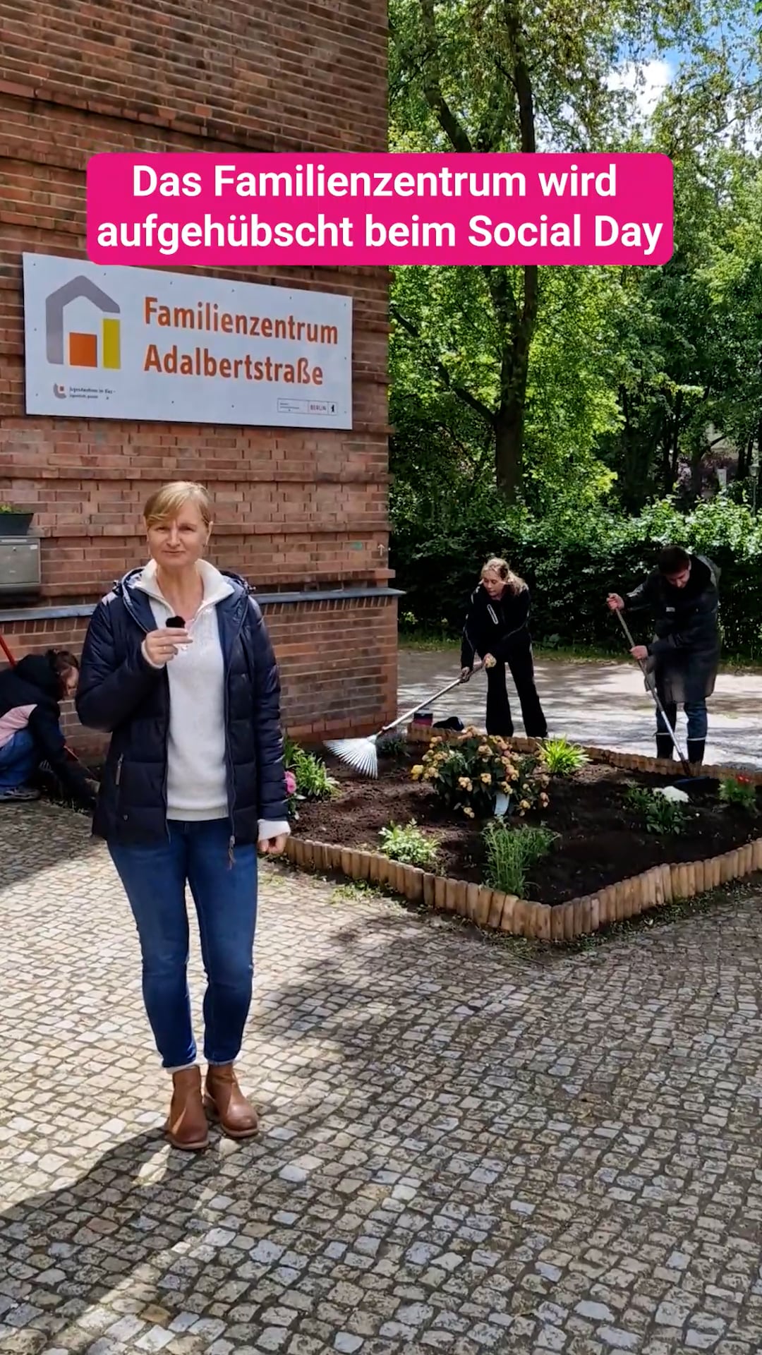 Frau Mai, Leitung vom Familienzentrum, steht vor dem Haus und spricht in ein Mikrophon