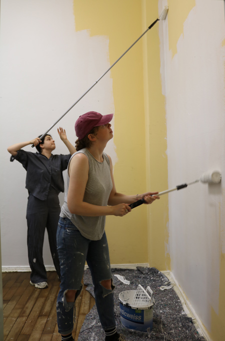 Mitarbeiter von Peak Ace streichen die Wand der Schulstation