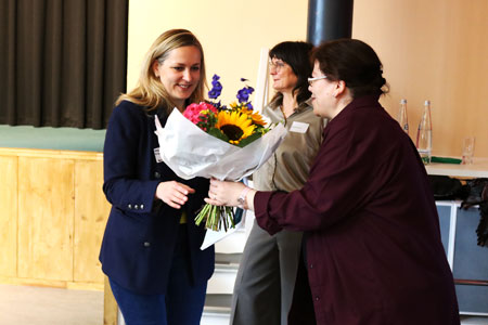 Blumenübergabe mit drei Frauen in den Räumlichkeiten der Berliner Stadtmission bei der TWG-Tagung